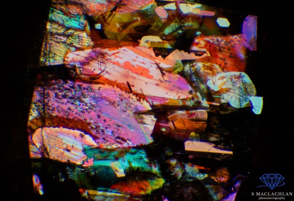 Foto 9: Questa è una sunstone (pietra del sole) della Tanzania. L’immagine è una sovrapposizione di 16 immagini in stacking ed è stata realizzata utilizzando solo illuminazione a fibra ottica, che si riflette magnificamente sulle piastrine di ematite, creando un arcobaleno di colori