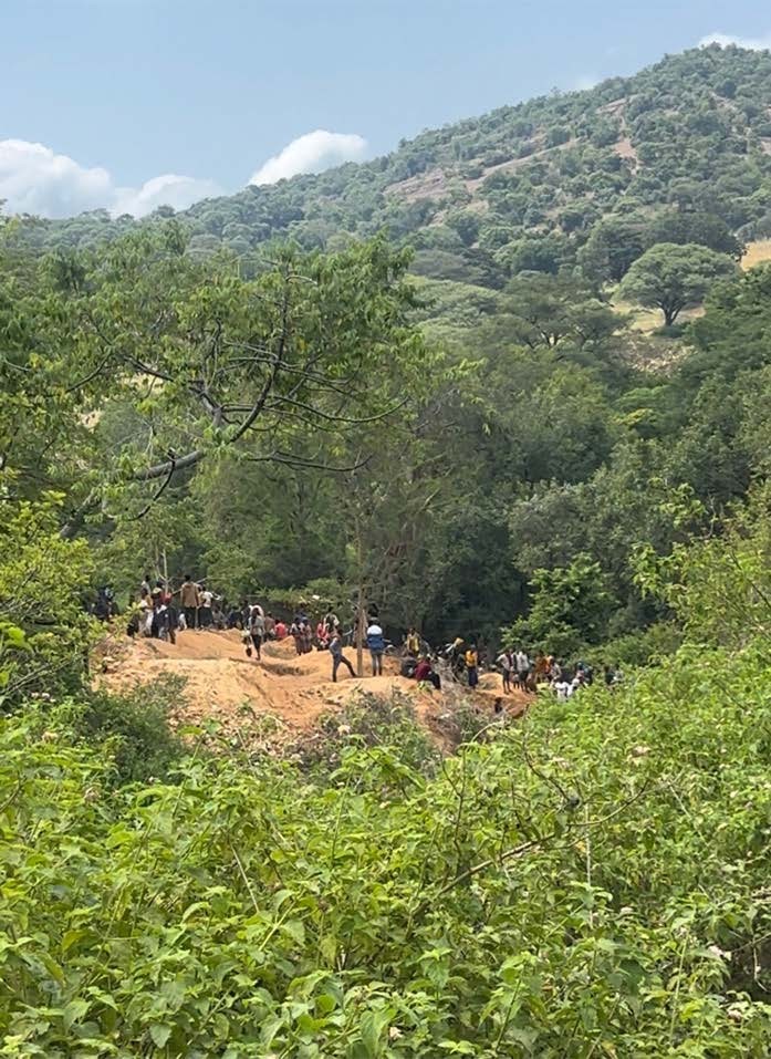 Prima veduta del sito minerario principale vicino al villaggio di Abuloo, dove centinaia di persone locali scavano il terreno usando semplici attrezzi manuali. Si trova in una piccola valle tra le colline lungo un ruscello